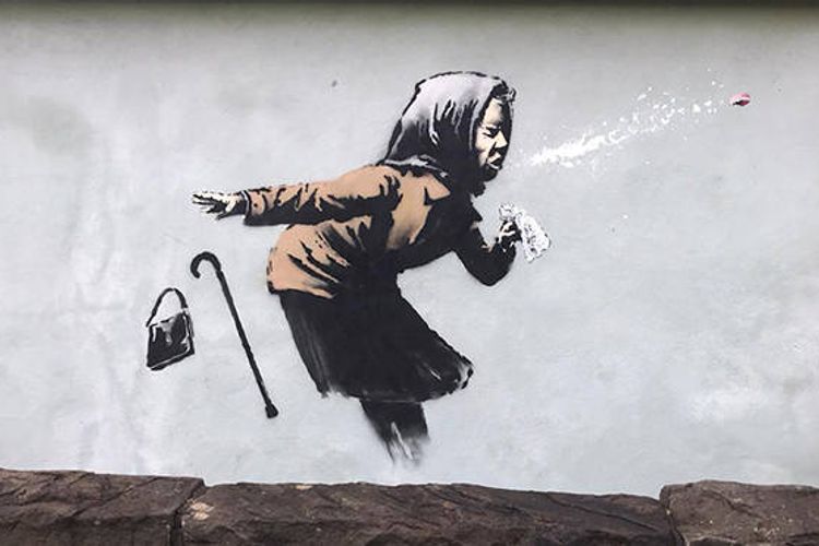 Cover your mouth! Banksy claims mural of sneezing woman in Bristol