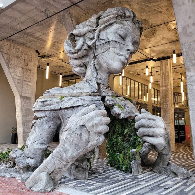 A Monumental Figure Reveals a Fern-Canopied Tunnel Inside Its Chest in Sculpture by Daniel Popper