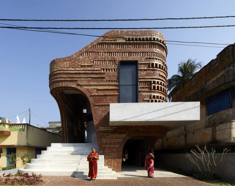 Varied Bricks and Ceramic Blocks Comprise the Asymmetric Facade of a Spacious Community Center in Bengal