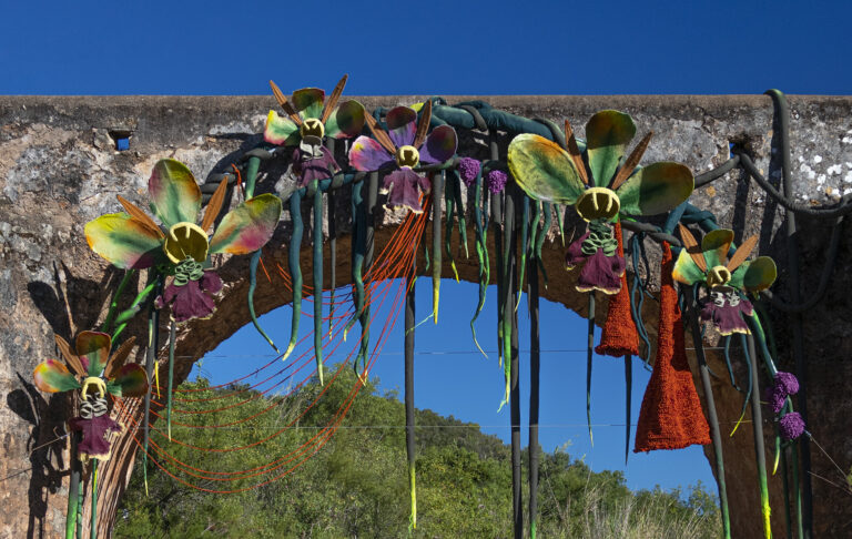 A Dreamy Fiber Installation by Vanessa Barragão Transforms a Medieval Bridge into a Patch of Oversized Orchids