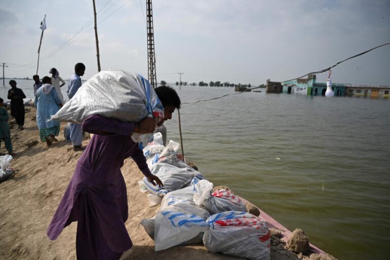 Pakistanis throw up barriers against rising floodwaters; 12 more die